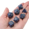 Set 7 dés multi-faces bleu-gris chiffres dorés.